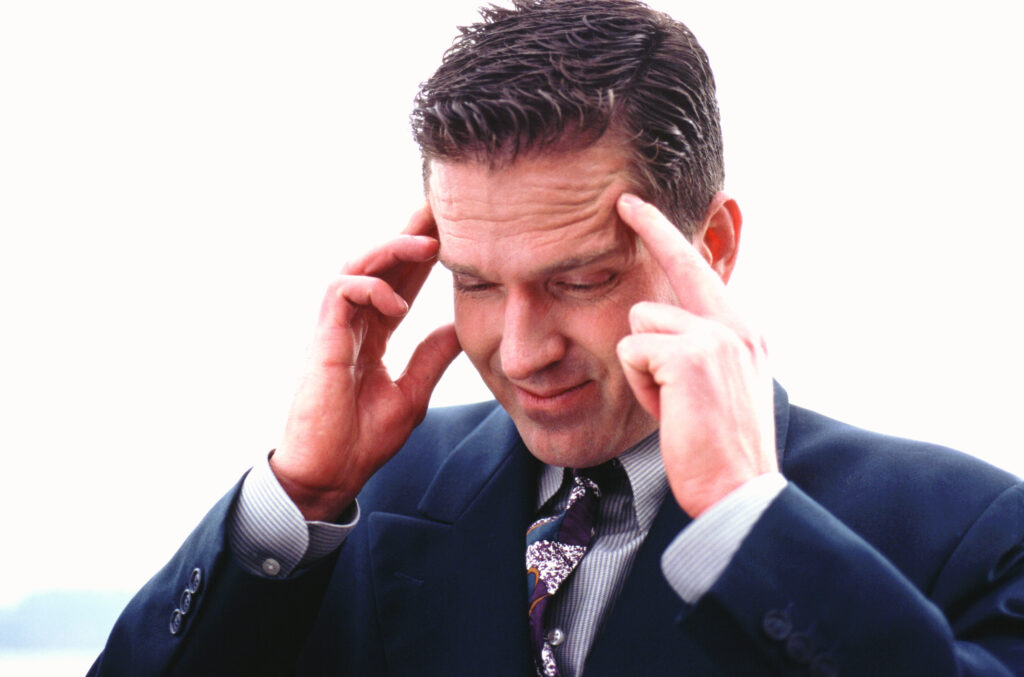 businessman with head in hands, looking down